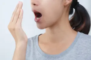 Asian Woman Checking Her Breath With Hand Test. Health Care Concept.